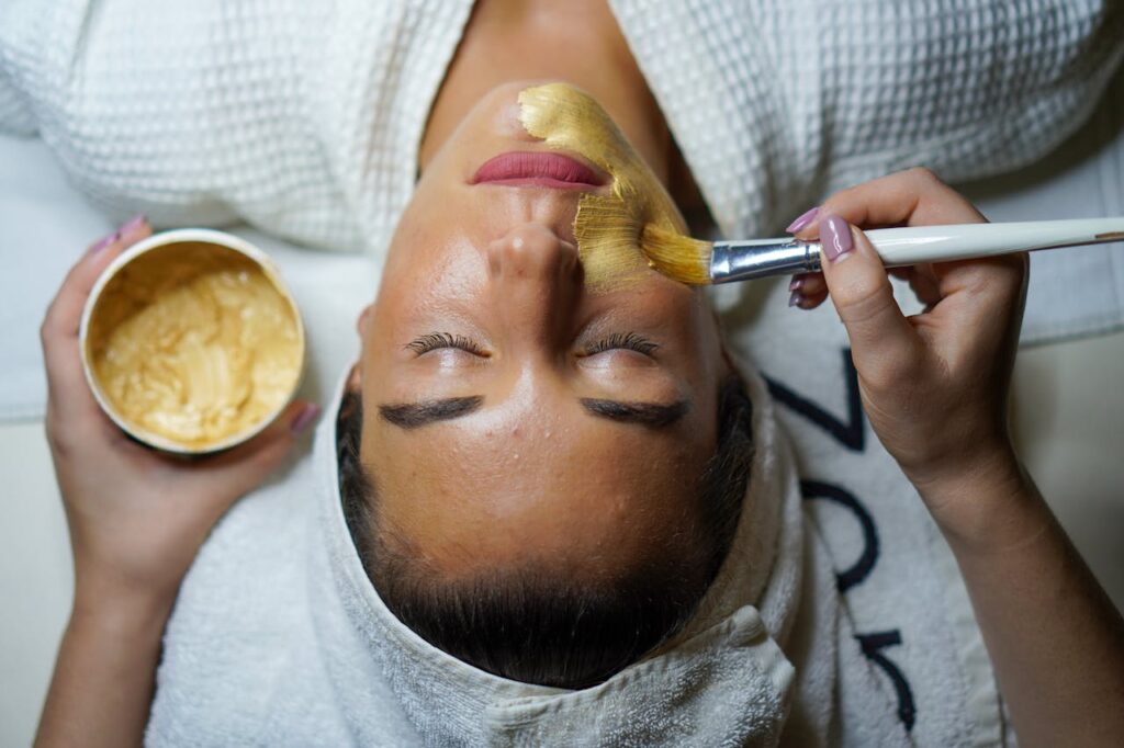 pexels-photo-3212179 A woman enjoying a gold facial mask for relaxation and skincare at a spa.